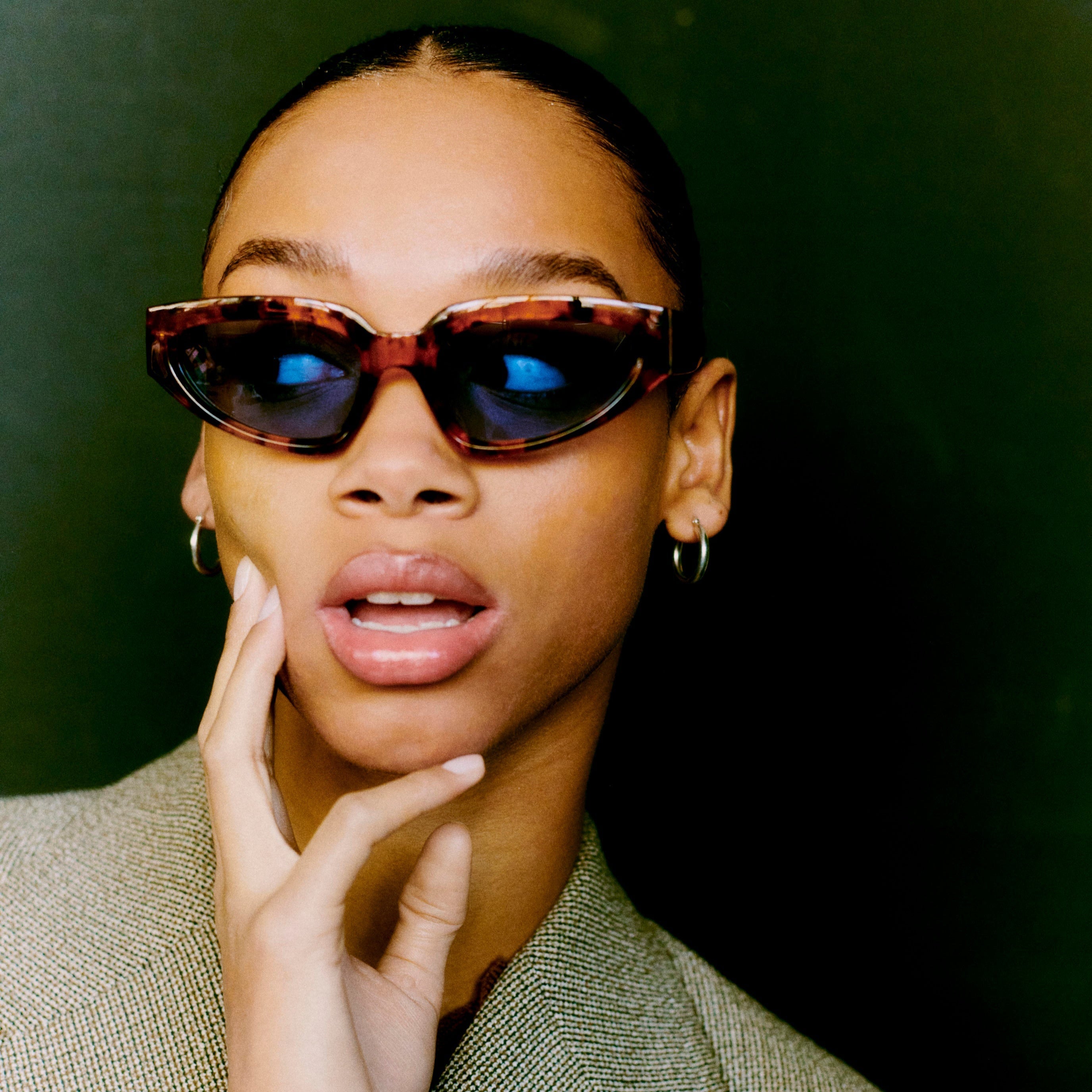 Woman wearing sunglasses with a dark background