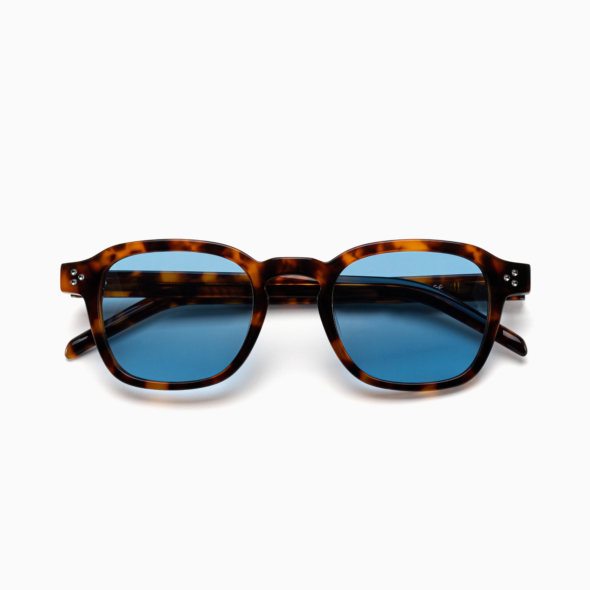 Sunglasses with tortoiseshell frame and blue lenses on a white background